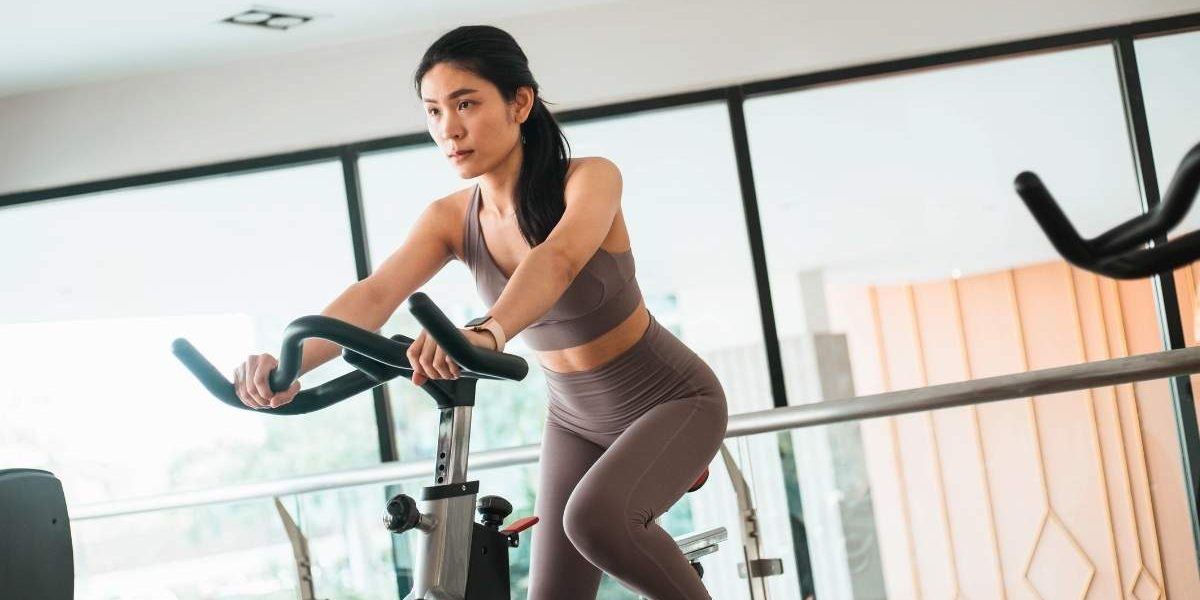 femme qui fait 30 minutes de vélo d'appartement par jour chez elle pour maigrir ou renforcer ses muscles