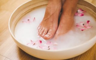 femme qui fait un bain de pied au bicarbonate de soude pour avoir des pieds doux et beaux