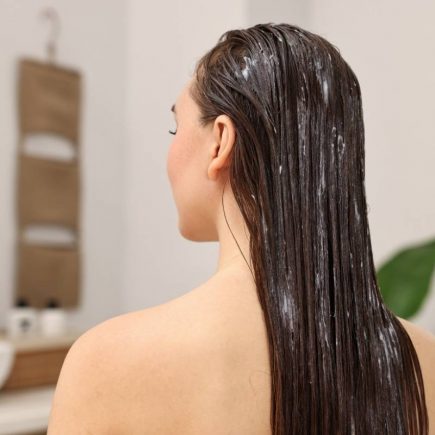 femme en train d'essayer un masque pour cheveux maison